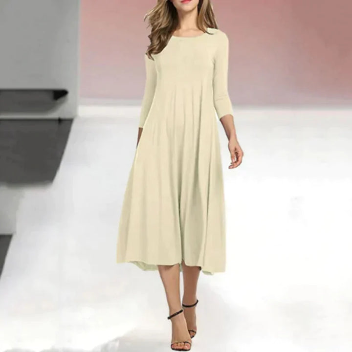 Dames zomerjurk: driekwart midi lengte, ronde hals. Comfortabele, elegante jurk perfect voor zomermode.