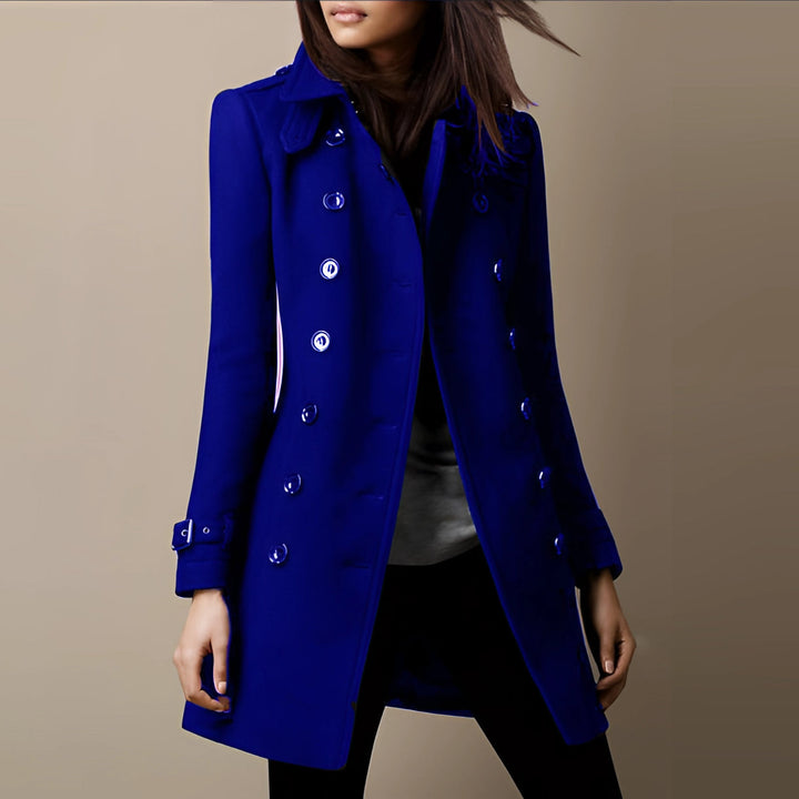 Dames trenchcoat gedragen door model, toont getailleerde pasvorm en elegante uitstraling. Modieus.