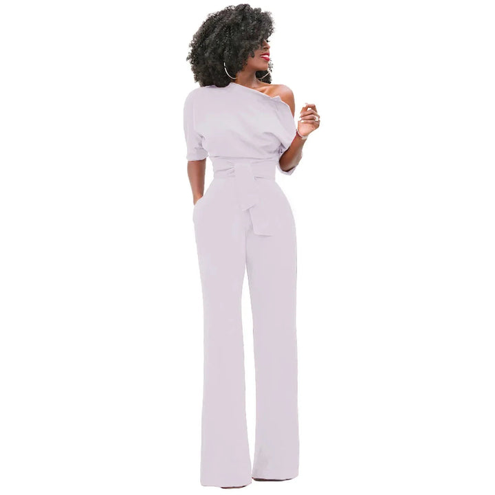 Chique dames jumpsuit met open schouder, strikband en flowy wijde pijpen.