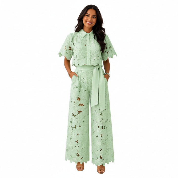 Model draagt een lichtgroene kanten crop top en wijde broek set met strikceintuur.