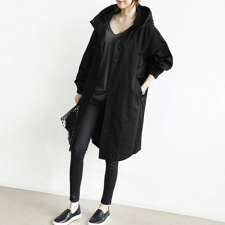 Zwarte lange damesjas met capuchon. Deze casual winterjas biedt warmte en stijl voor elk tussenseizoen.