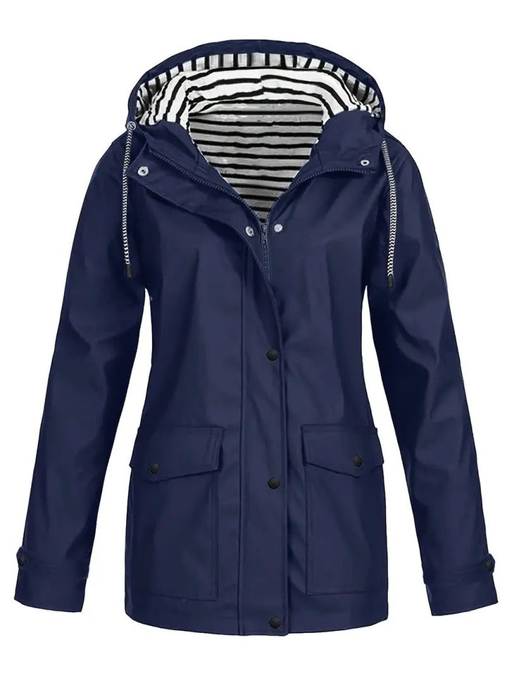 "Dames regenjas met strepenvoering, verstelbare capuchon, waterafstotend in modern marineblauw, perfecte herfststijl."