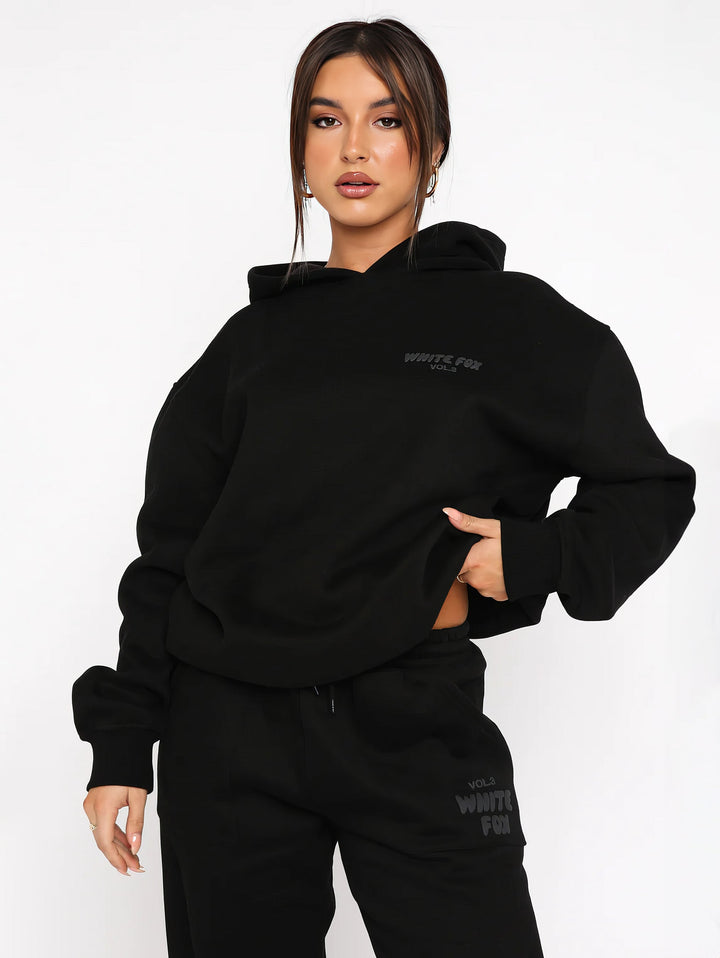 "Dames trainingspak met oversized pasvorm, wit, elastische ribboorden, trendy puffprint logo en fleecestof."