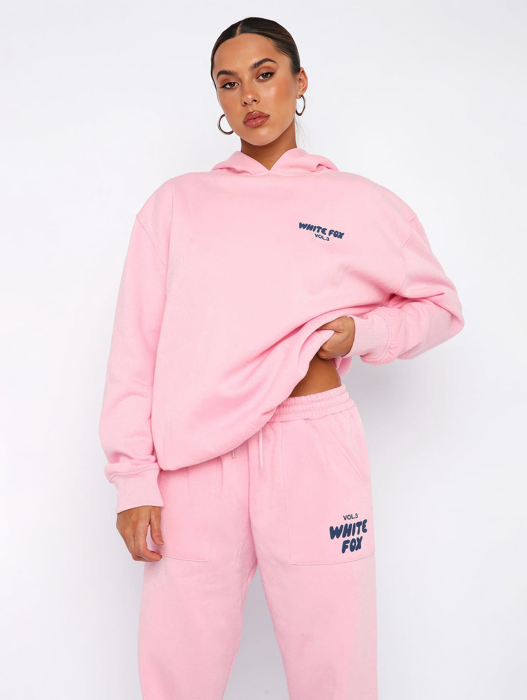"Dames trainingspak met oversized pasvorm, wit, elastische ribboorden, trendy puffprint logo en fleecestof."