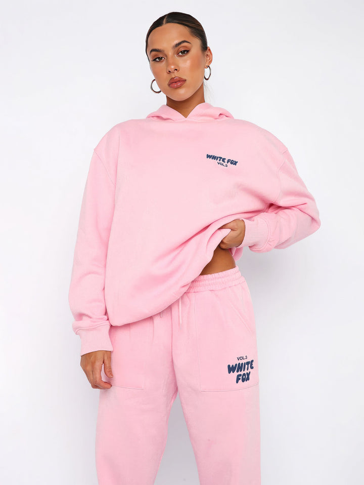 "Dames trainingspak met oversized pasvorm, wit, elastische ribboorden, trendy puffprint logo en fleecestof."
