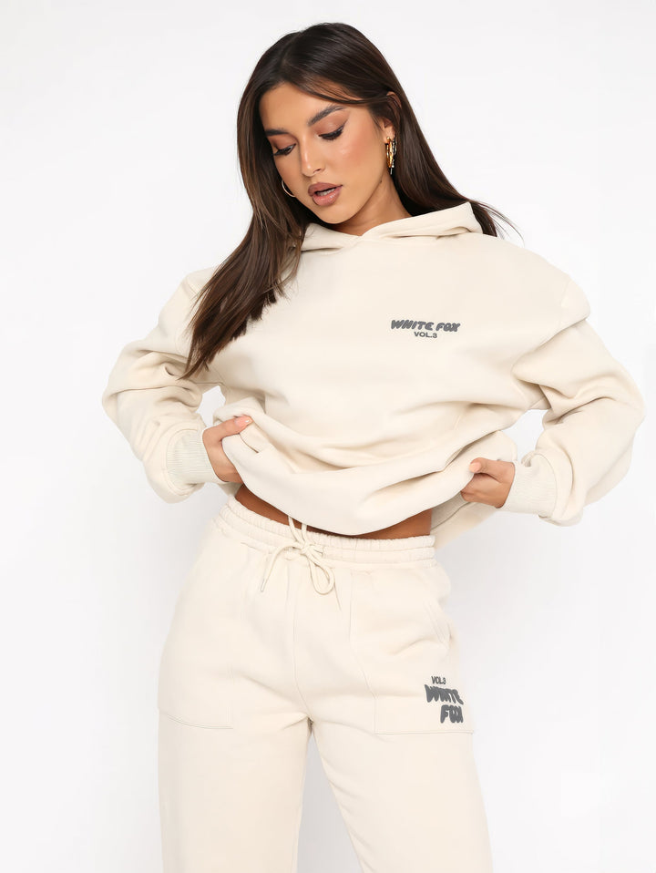"Dames trainingspak met oversized pasvorm, wit, elastische ribboorden, trendy puffprint logo en fleecestof."