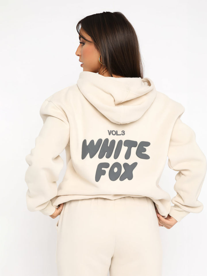 "Dames trainingspak met oversized pasvorm, wit, elastische ribboorden, trendy puffprint logo en fleecestof."