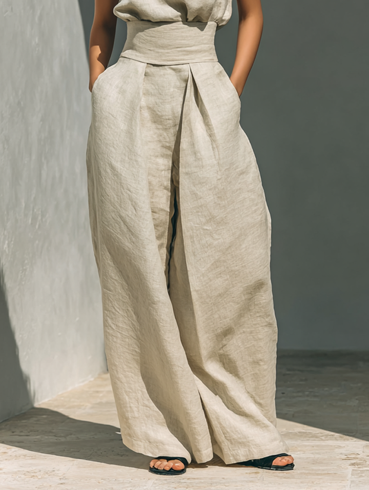 Zijaanzicht van model in de dames tweedelige set, toont de pasvorm van de mouwloze colkraag top en wijde broek.