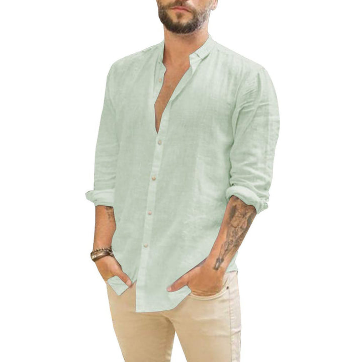 Model draagt een casual effen herenoverhemd met lange mouwen, ideaal voor een relaxte zomerlook.