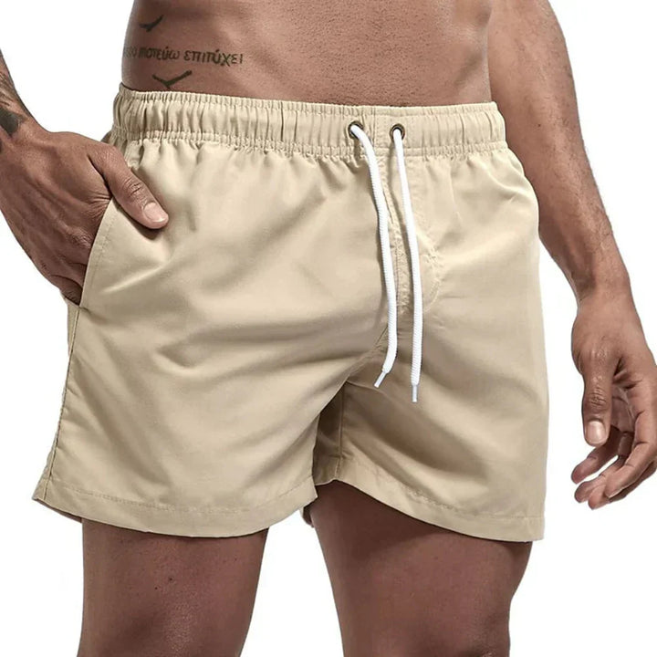 Man in heren zwemshorts aan het zwembad, genietend van de zon en ontspanning. Perfecte badkleding.