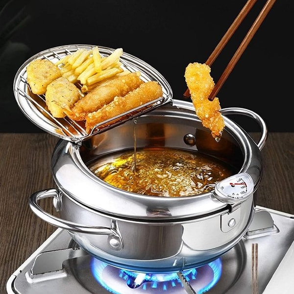 Friteuse met ingebouwde thermometer en frietjes op het dekselrooster