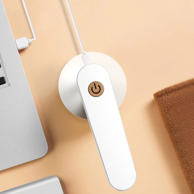 "Draadloze pluizenverwijderaar met groen-wit design, ergonomisch voor kleding en meubels onderhoud, compact en efficiënt."