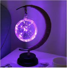 "Dromerige maanlamp van borosilicaatglas met zachte LED-gloed, creëert een betoverende sfeer op tafel."