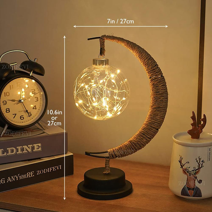 "Dromerige maanlamp van borosilicaatglas met zachte LED-gloed, creëert een betoverende sfeer op tafel."