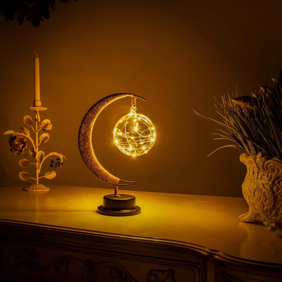 "Dromerige maanlamp van borosilicaatglas met zachte LED-gloed, creëert een betoverende sfeer op tafel."