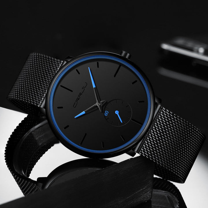 "Dun minimalistisch herenhorloge met elegante zwarte wijzerplaat, roestvrijstalen mesh-band en luxe uitstraling."