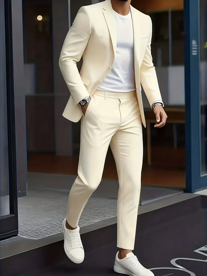 Man draagt beige slim fit herenkostuum met witte sneakers