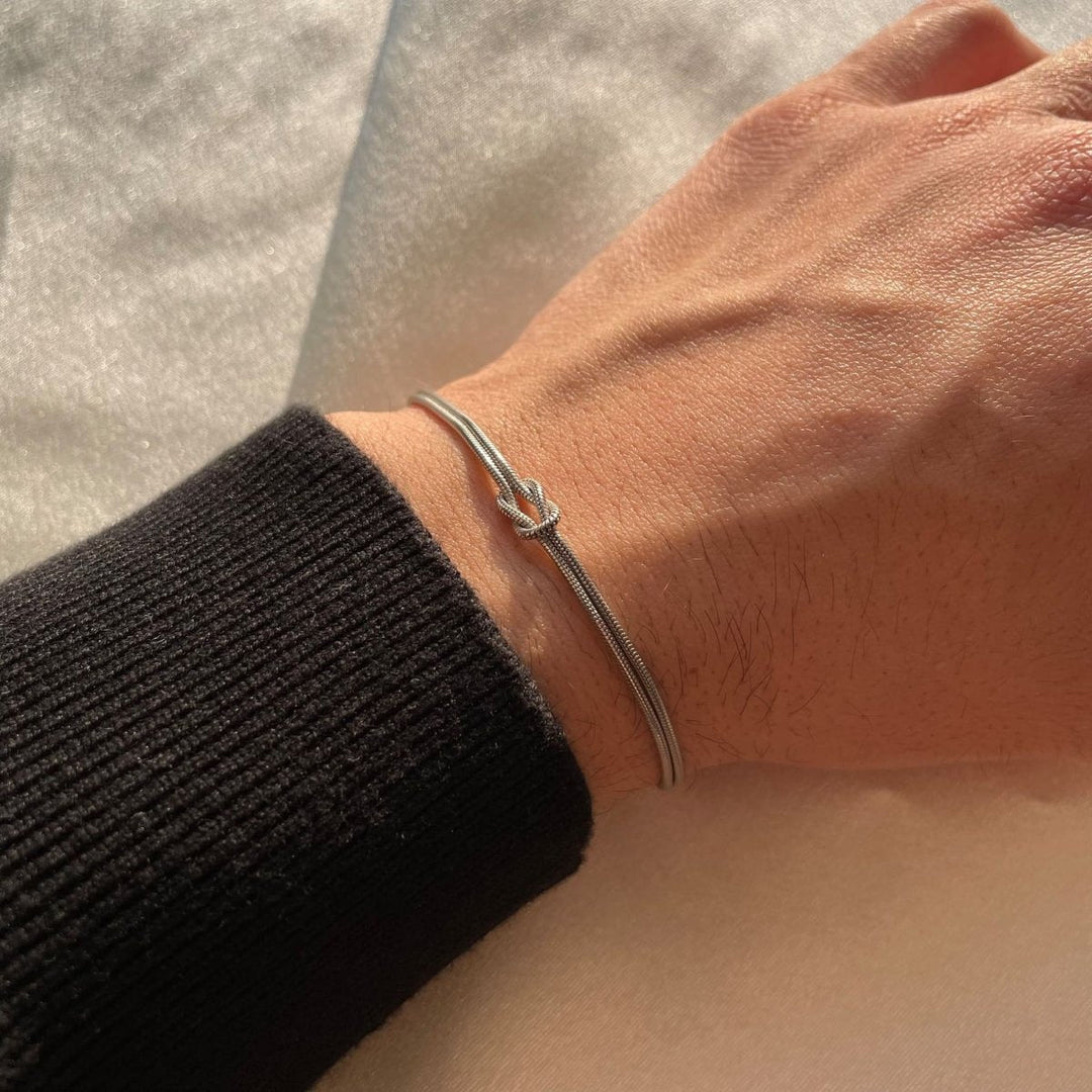 "Elegant gouden liefdesknoop armband voor dames, minimalistisch ontwerp, tijdloos en verfijnd accessoire."