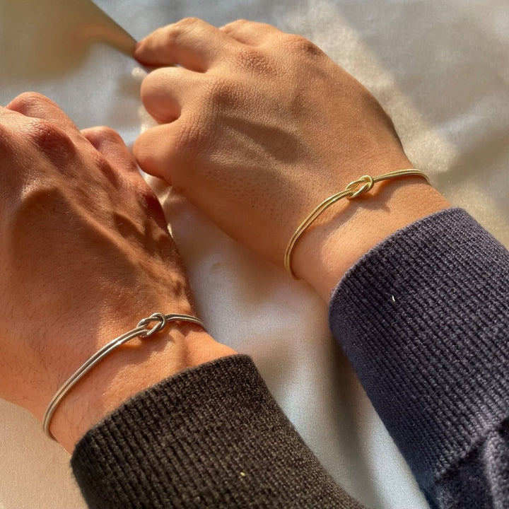 "Elegant gouden liefdesknoop armband voor dames, minimalistisch ontwerp, tijdloos en verfijnd accessoire."