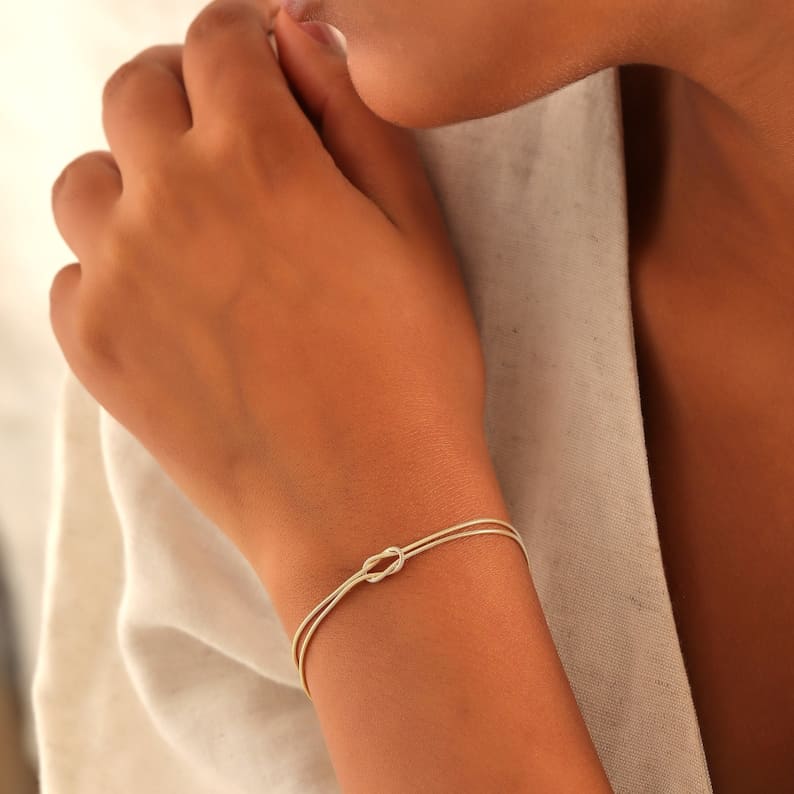 "Elegant gouden liefdesknoop armband voor dames, minimalistisch ontwerp, tijdloos en verfijnd accessoire."