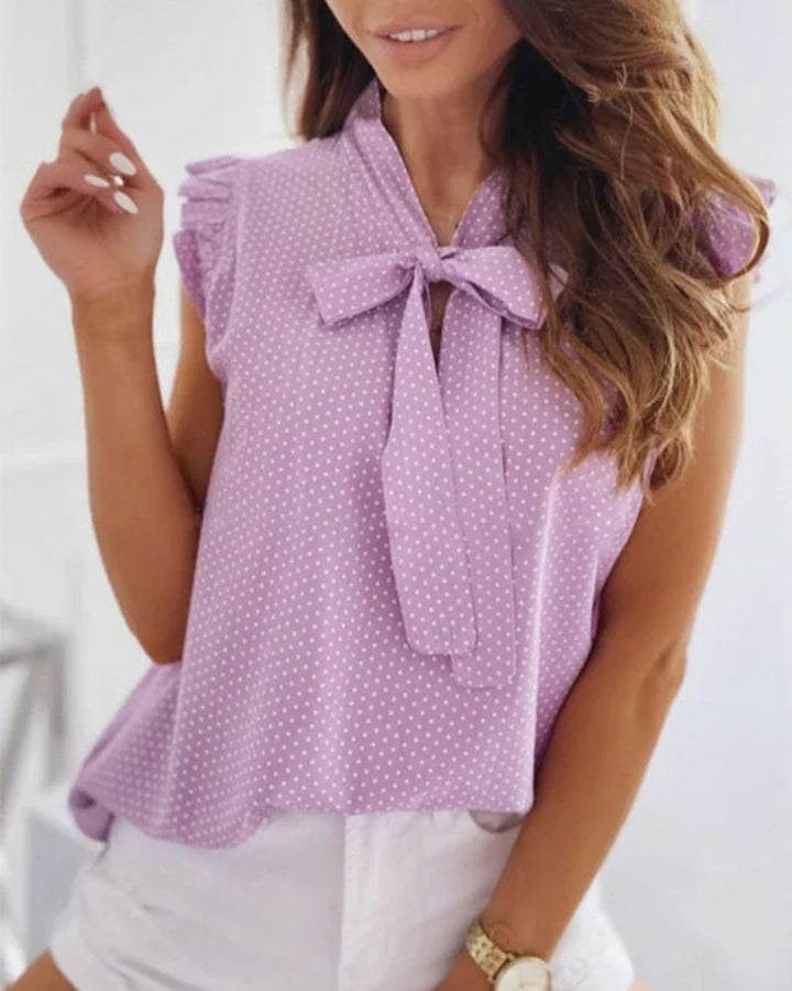 "Elegante Brianna damesblouse met polkadots, strikdetail en ruffles; luchtige zomertop voor veelzijdige stijl."