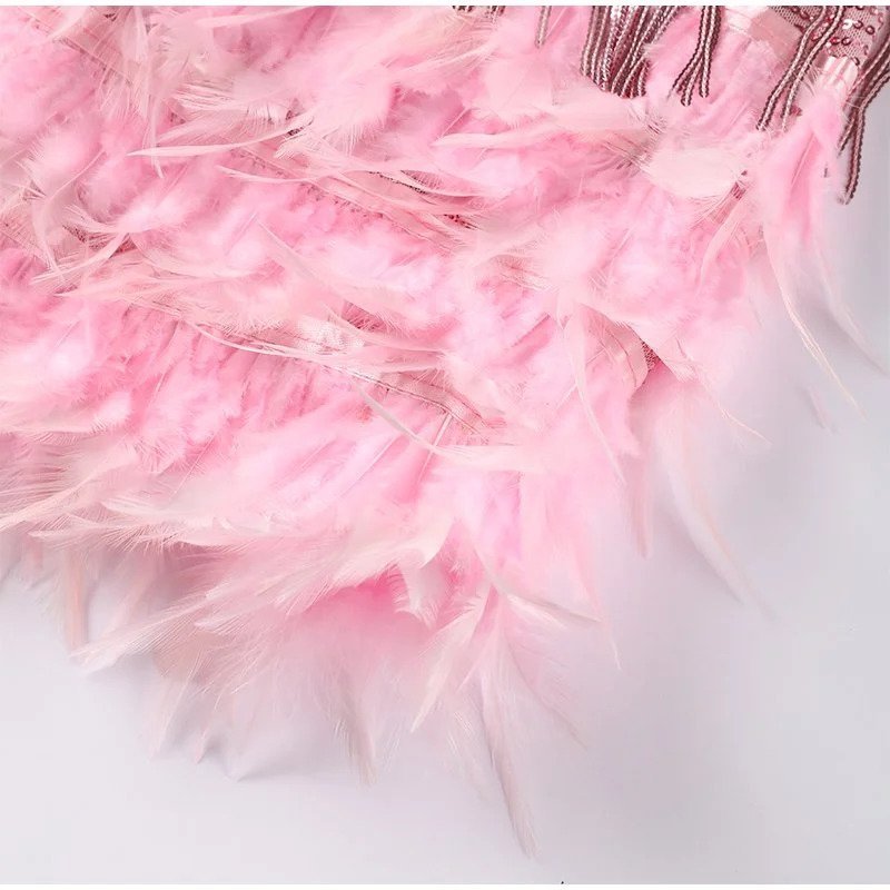 "Elegante cocktailjurk met franjes en veertjes, perfect voor feestjes, met aansluitende pasvorm en uitlopende rok."