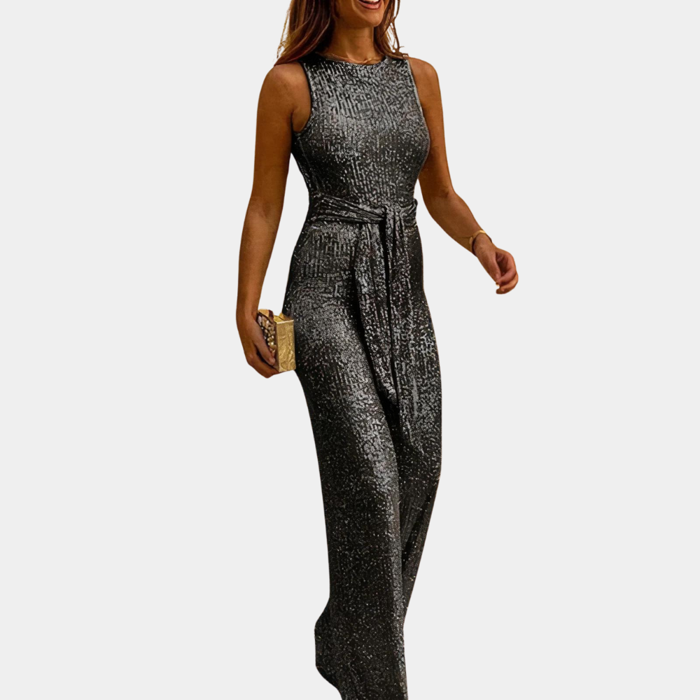 Close-up van de sprankelende glitterstof van deze chique dames jumpsuit, ideaal voor een bruiloftsgast.
