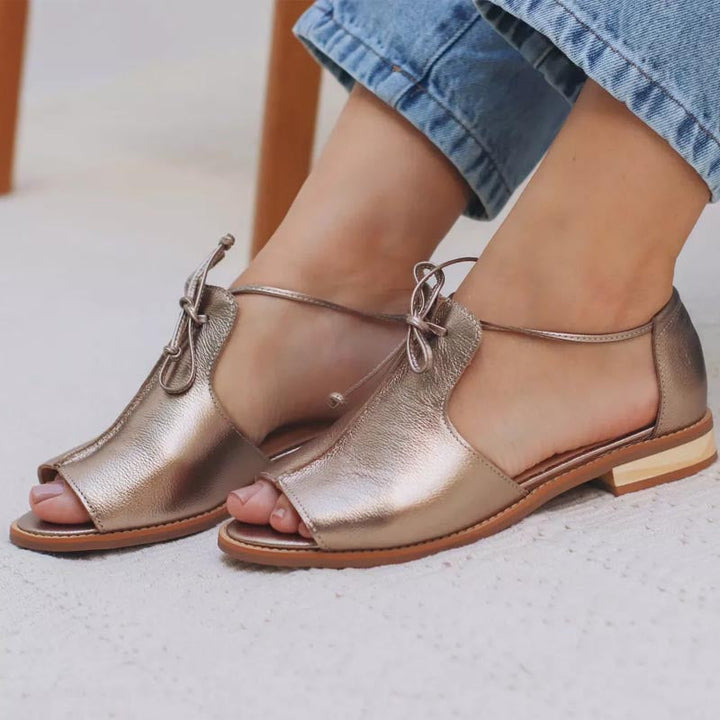 Zilveren dames sandalen, platte zool, open neus en chique strikbandje. Ideaal als elegante zomerschoenen voor dames.