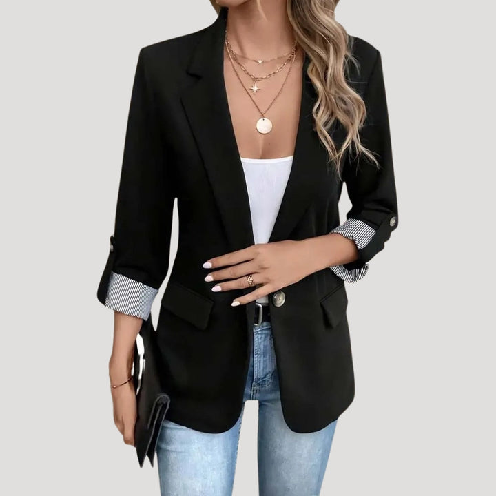 Close-up van elegante damesblazer met verfijnde kraag, getailleerd model en trendy opgerolde mouwen voor stijlvolle outfits.