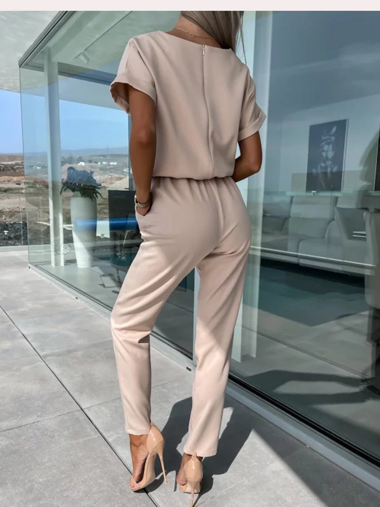 Chique roze dames jumpsuit met korte mouw, V-hals en een strikceintuur, ideaal voor diverse gelegenheden.