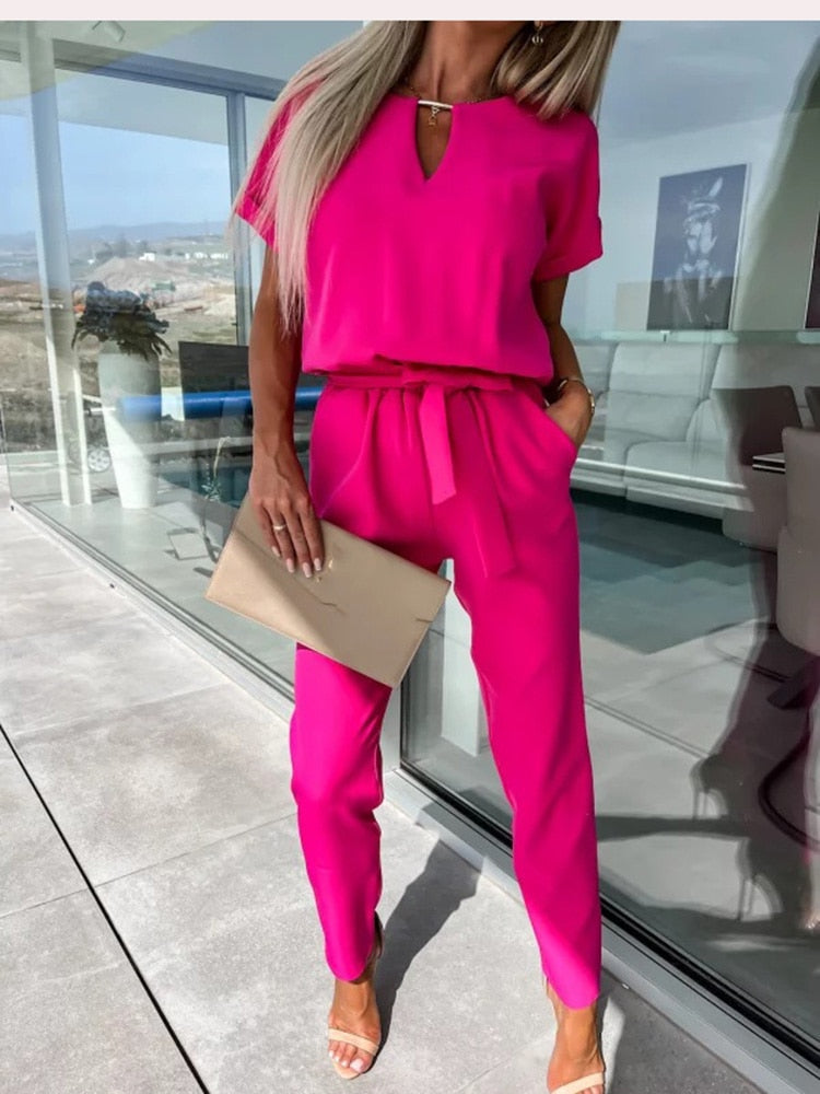 Modieuze zwarte avond jumpsuit voor dames; V-hals, korte mouw en strikceintuur voor een chique look.