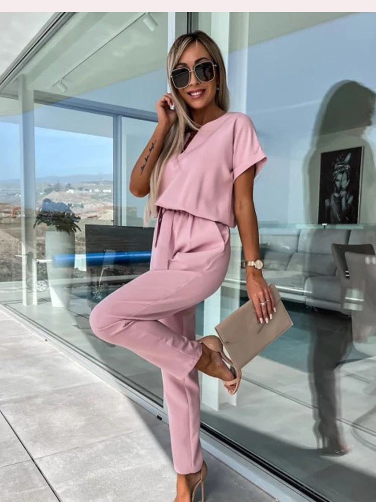 Veelzijdige roze dames jumpsuit, geschikt voor casual of chique gelegenheden, met korte mouw en V-hals.