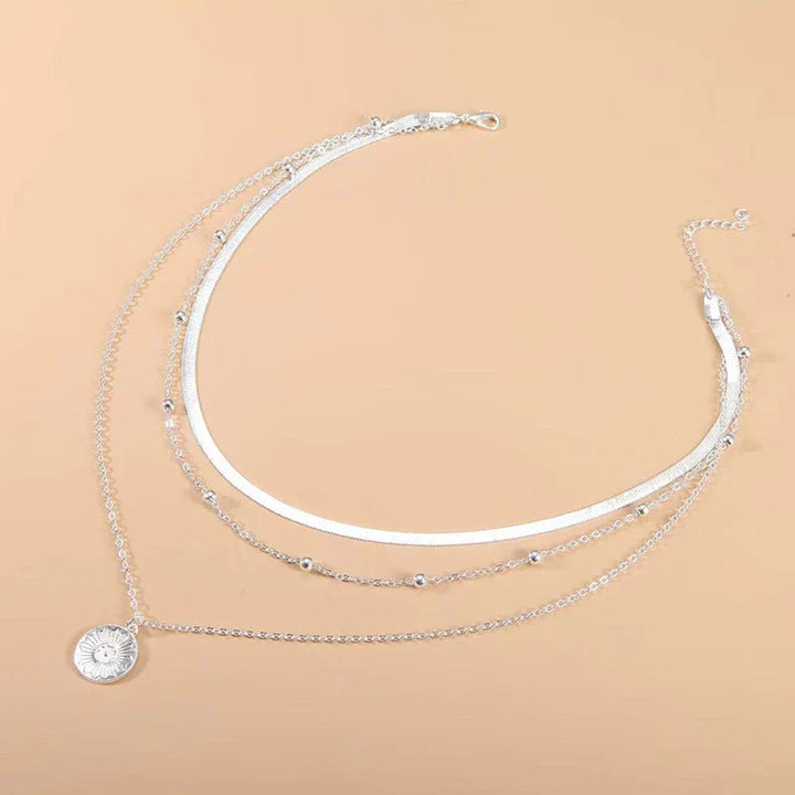 Zilverkleurige drievoudige ketting, minimalistisch ontwerp, geschikt voor elke gelegenheid.