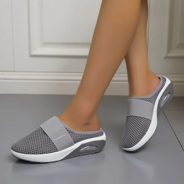 Elegante zwarte orthopedische damesslippers met ademend ontwerp en comfortabel voetbed voor langdurig draagcomfort.