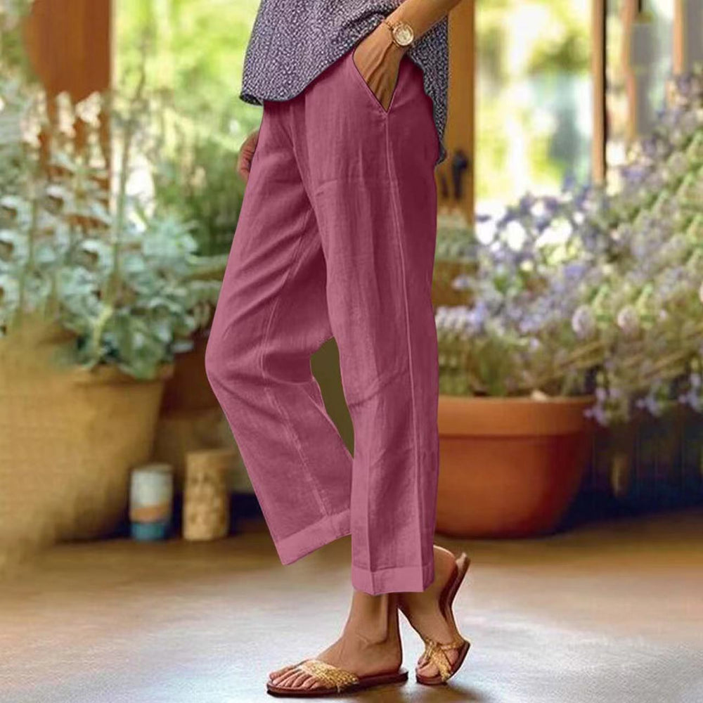 Model draagt comfortabele cropped broek in roodpaarse kleur met een ontspannen, zomerse top.