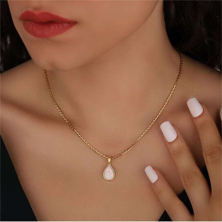 Natuurlijke opaal druppelhanger aan een 18K gouden dames ketting; een elegant en tijdloos sieraad.
