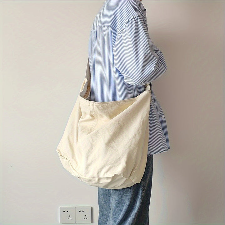 Ruime heren canvas schoudertas met minimalistisch design. Ideaal voor laptop, boeken of dagelijkse benodigdheden.