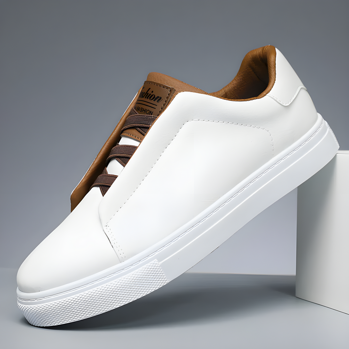 Witte heren sneakers met bruine accenten op een grijze achtergrond