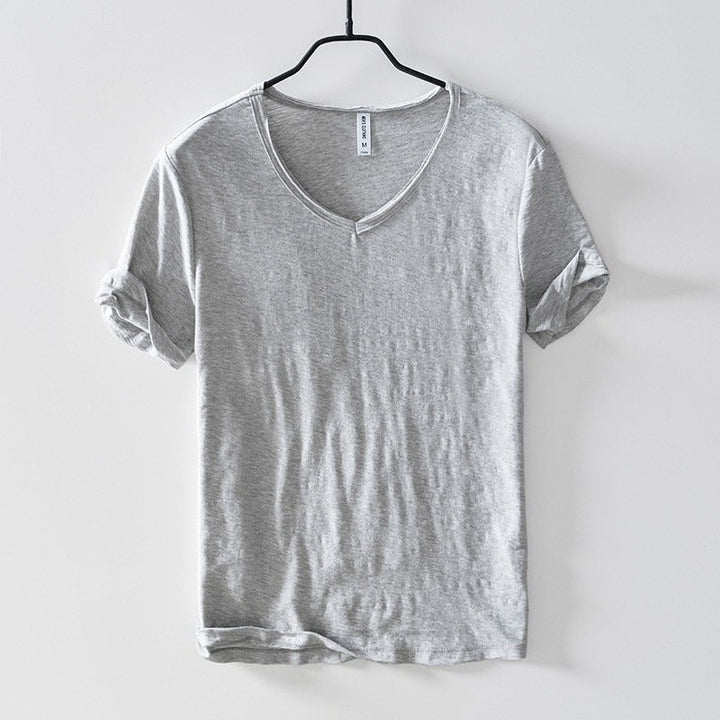 Heren T-shirt met diepe V-hals in grijs, hangend op een hanger, focus op pasvorm en gerolde mouwen.