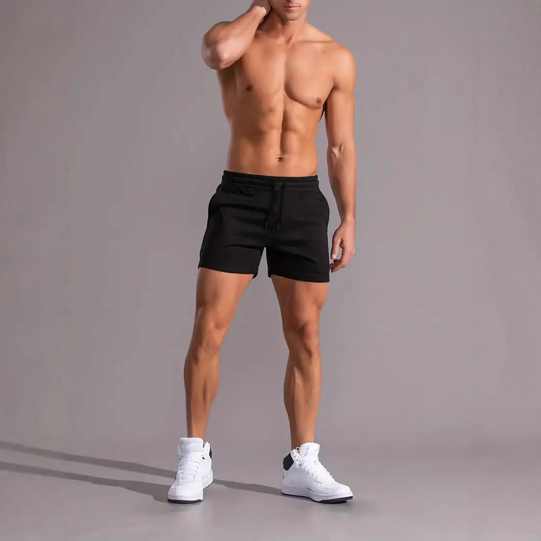 Afgetrainde man met zwarte sportshort en witte sneakers