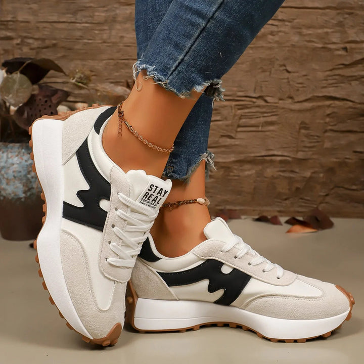 Witte dames platform sneakers met zwarte strepen, sportief en trendy.