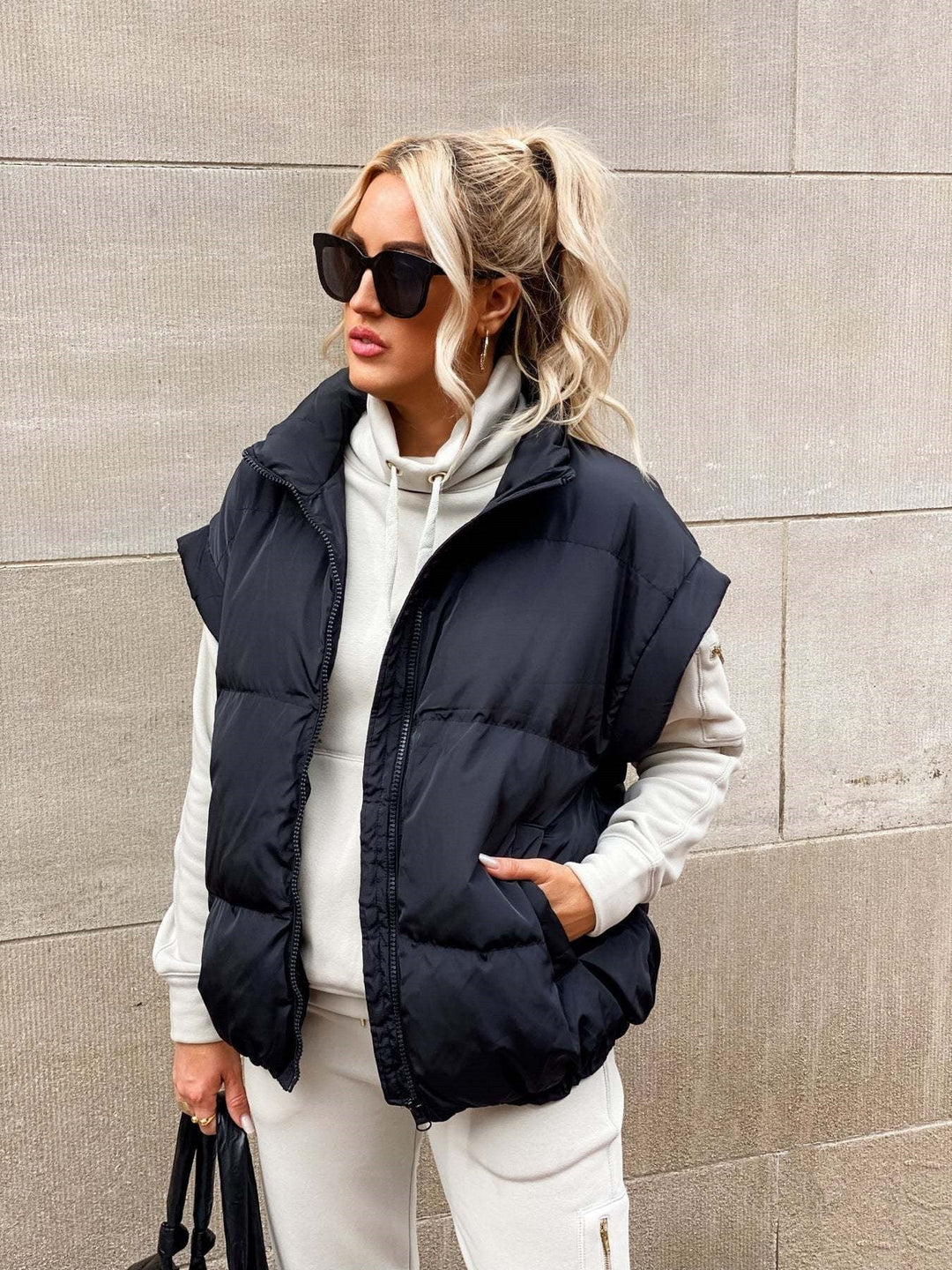 Close-up van zwart gewatteerd puffer vest voor dames met opstaande kraag