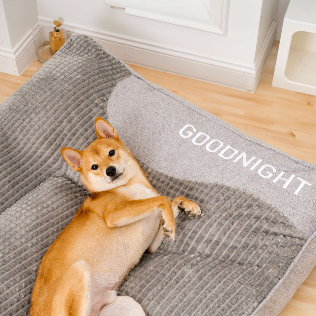 Groot wasbaar orthopedisch hondenkussenbed met nekondersteuning in bruin of grijs design.