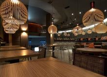 "Handgemaakte houten hanglamp, rustiek design, zichtbare houtnerf, warme sfeer, interieurverlichting, uniek en duurzaam."