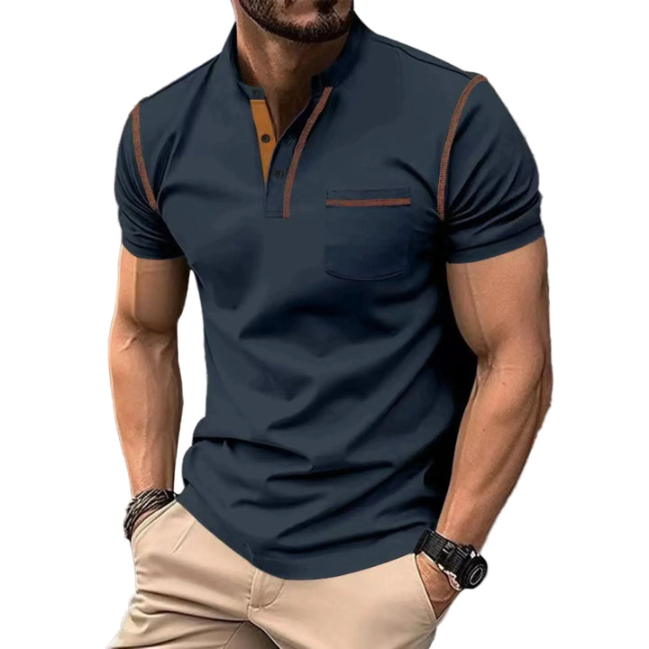 Stijlvolle donkerblauwe heren polo met opstaande kraag en contrastbies gedragen door een man.
