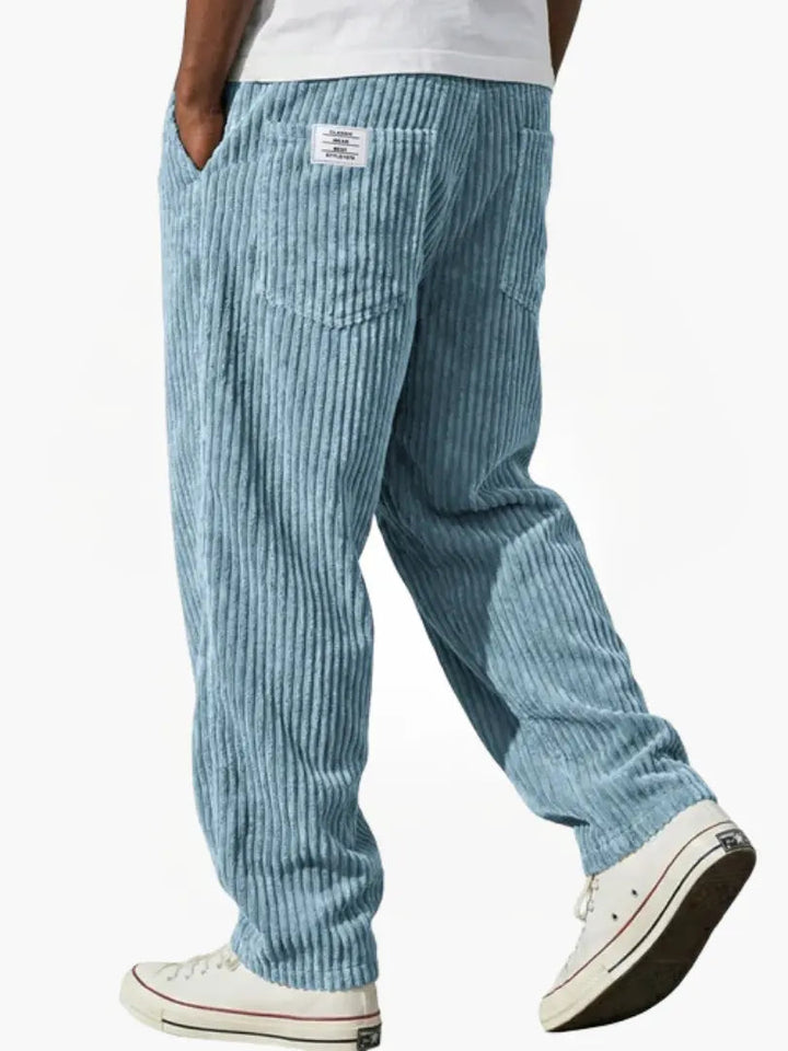Man draagt een casual ribbroek met elastische tailleband en steekzakken. Comfortabele herenmode voor vrije tijd.