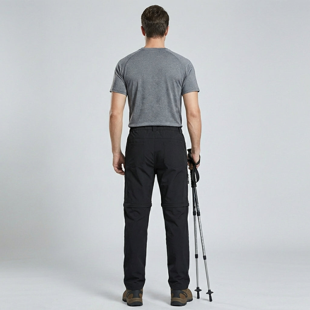 Man van achteren met comfortabele outdoorbroek, toont flexibele pasvorm.