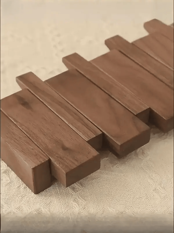 "Houten kapstok met pianotoets design, gemaakt van duurzaam walnoot- en beukenhout, voorzien van meerdere haken."