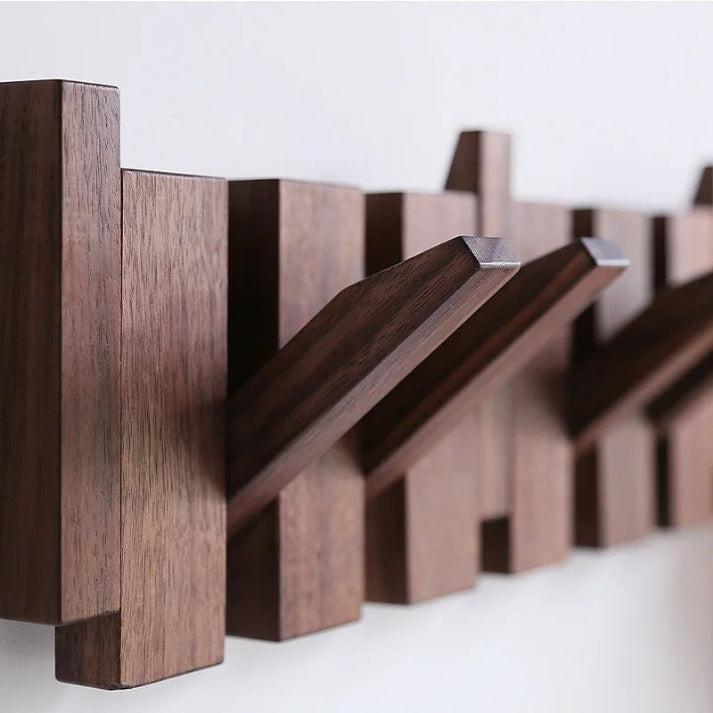 "Houten kapstok met pianotoets design, gemaakt van duurzaam walnoot- en beukenhout, voorzien van meerdere haken."
