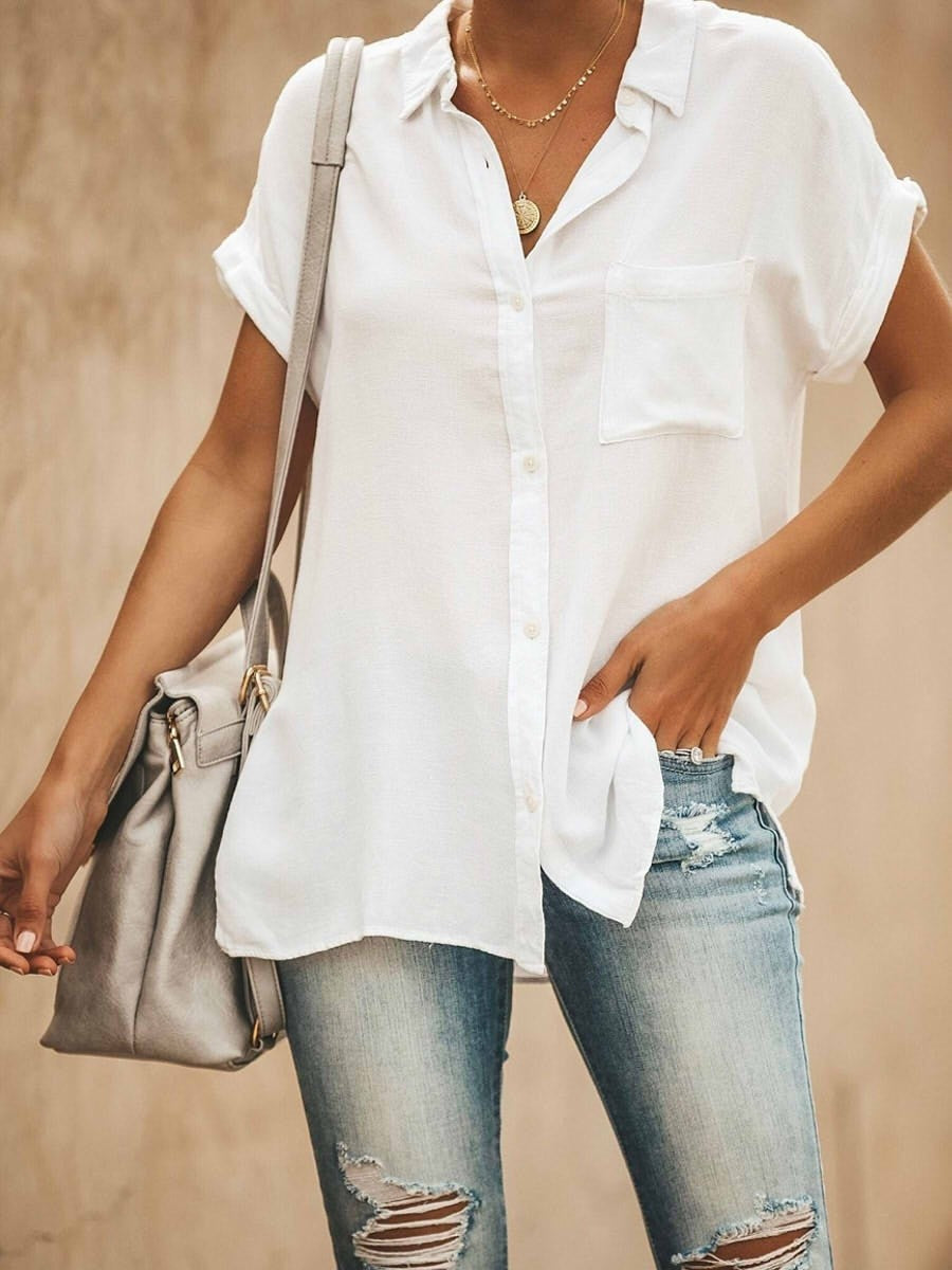 Model draagt een witte dames blouse met korte mouwen en knopen